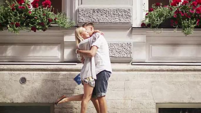 女友和男朋友正在欧洲小镇见面和拥抱。
