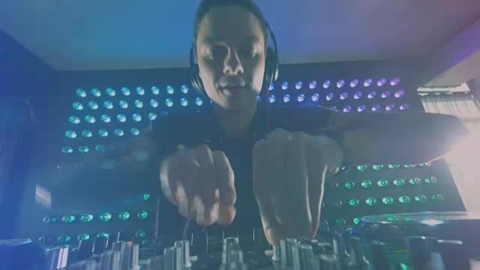 DJ在他的调音台上使用不同的旋钮进行实验。