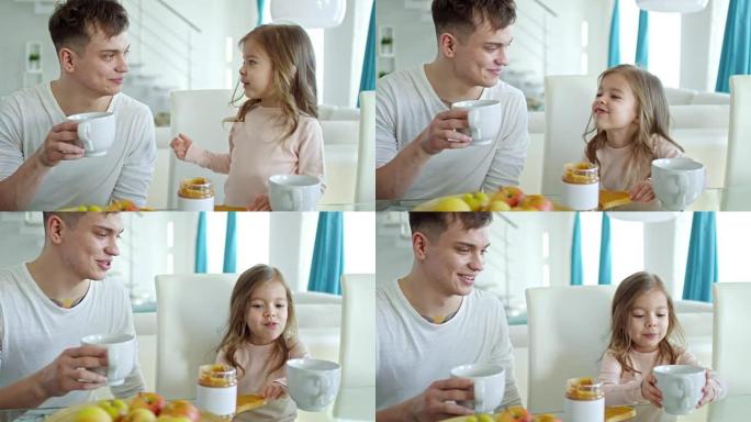 快乐的父亲和可爱的女儿在早餐时聊天
