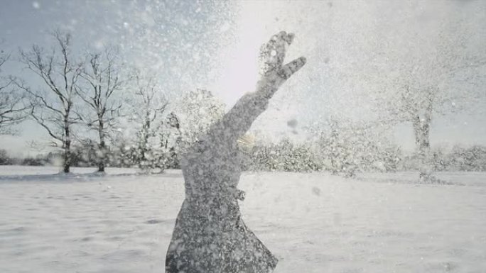 慢动作: 开朗的女人在空中撒雪