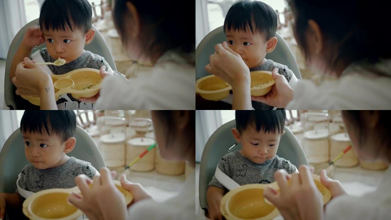 婴儿在喂食椅上吃饭。