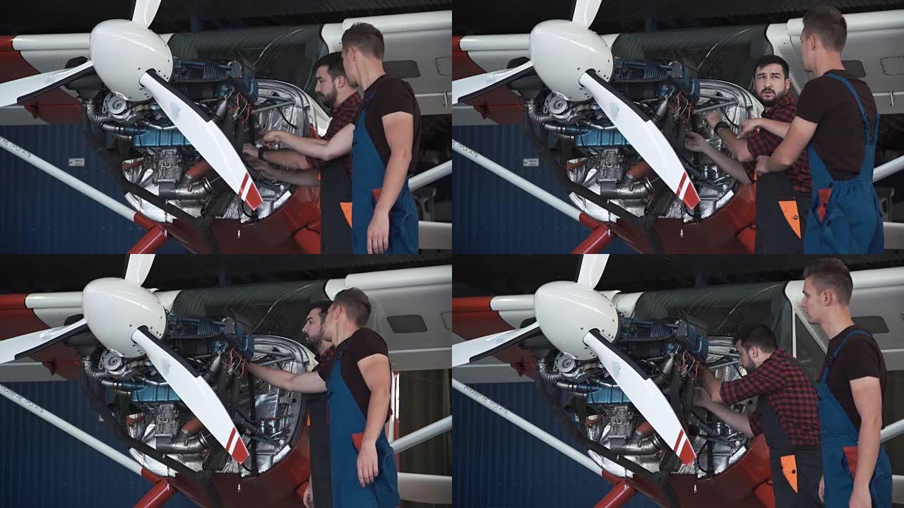 两名机械师在一架小型飞机上工作