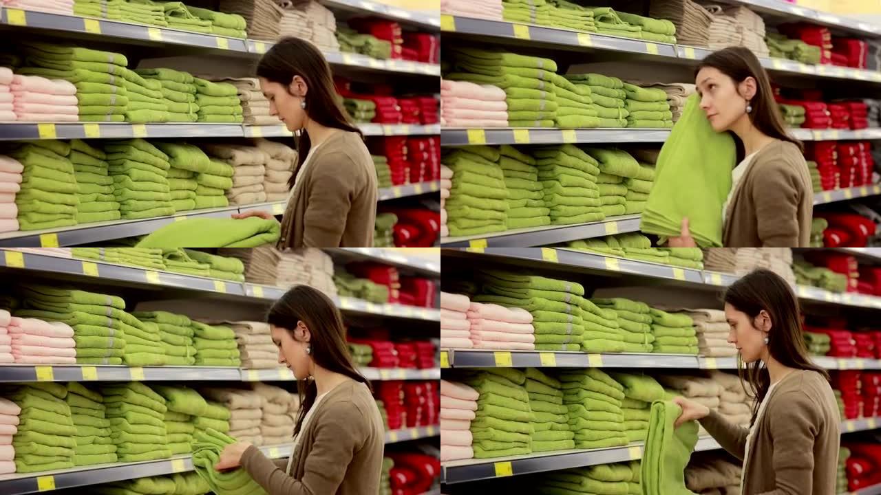 年轻女子在超市里选择毛巾