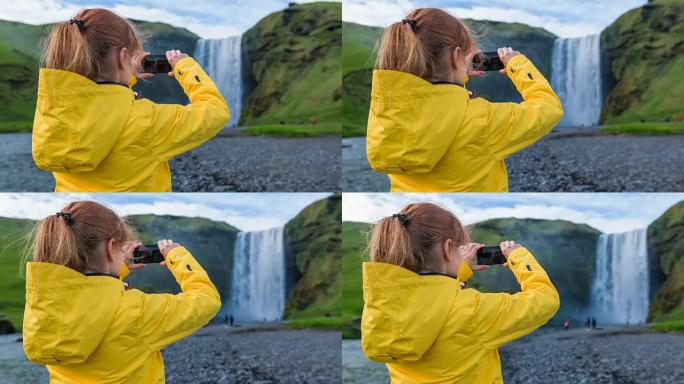女人为冰岛的瀑布Skogafoss拍照