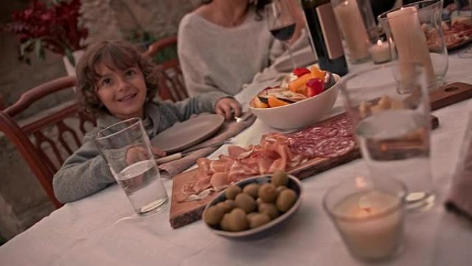 坐在地中海村家庭餐桌上的小男孩
