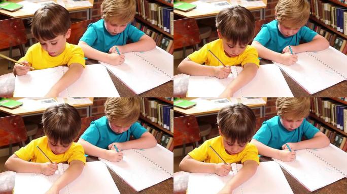 可爱的小学生在图书馆写作