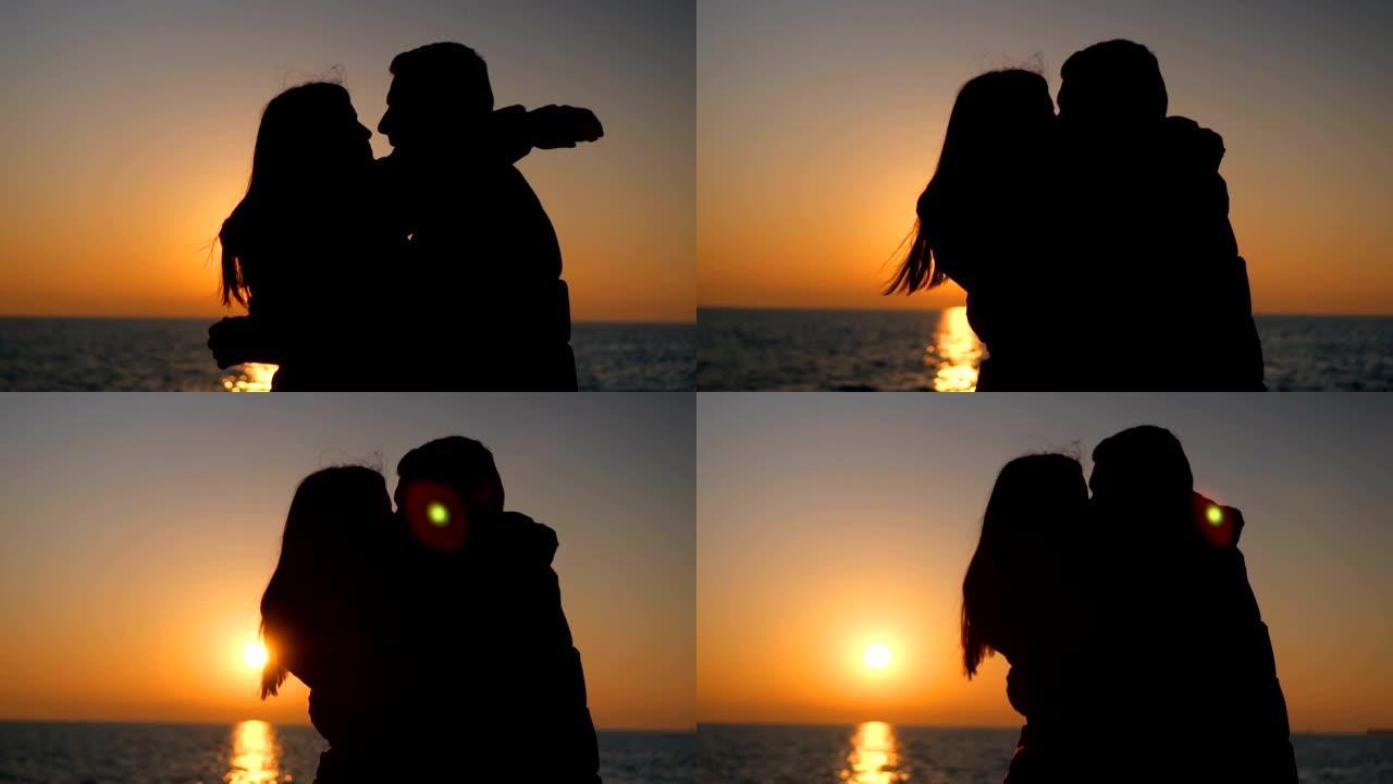 日落时浪漫情侣见面的剪影