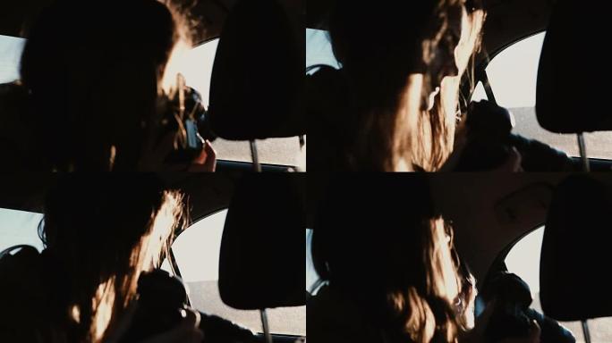 车内视图。旅游妇女开车旅行并在窗外拍摄日落风景