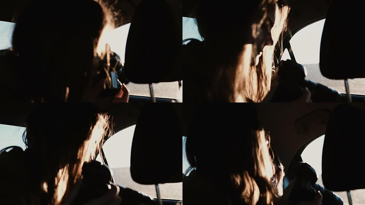 车内视图。旅游妇女开车旅行并在窗外拍摄日落风景