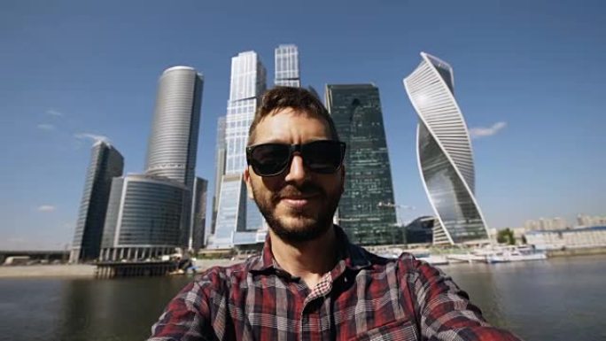 莫斯科国际商务中心附近使用智能手机自拍的快乐旅游男子