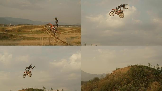 慢动作: 专业骑自行车的人在尘土飞扬的摩托车越野赛道上跳了大空中技巧