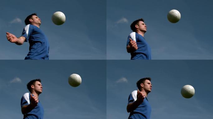 足球运动员在蓝天下接球