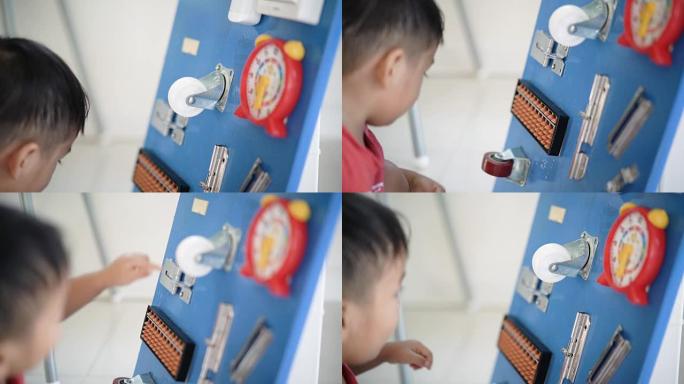 SLO MO亚洲男婴玩DIY忙碌的棋盘益智游戏。