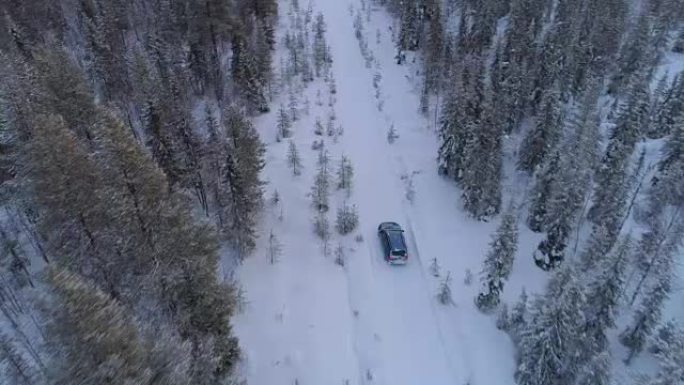 在拉普兰冬季森林的雪路上，空中汽车驶过湿滑的弯道