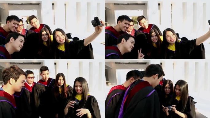 一群穿着砂浆板和单身汉礼服的快乐国际学生，带着文凭在户外用小型相机自拍。教育、毕业、技术和人的概念。