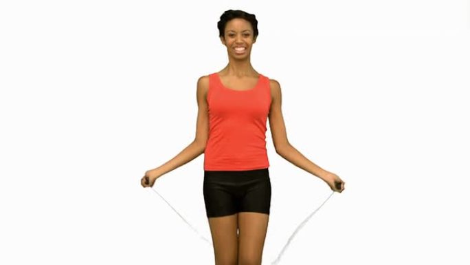 开朗的女人在白色屏幕上用绳子锻炼