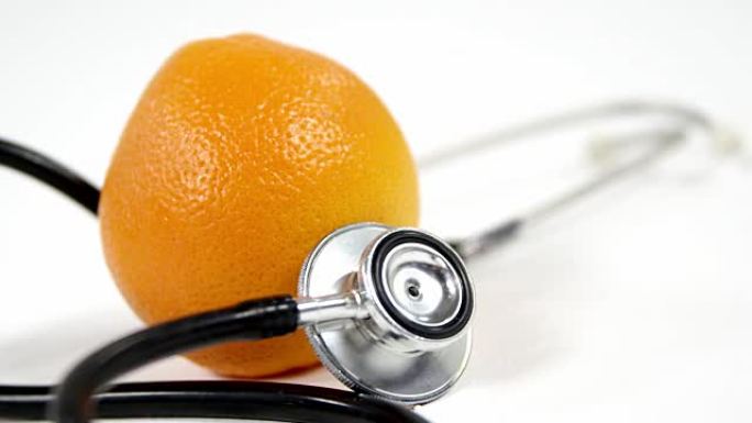 听诊器和白色背景上的橙色水果