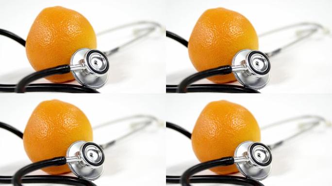 听诊器和白色背景上的橙色水果