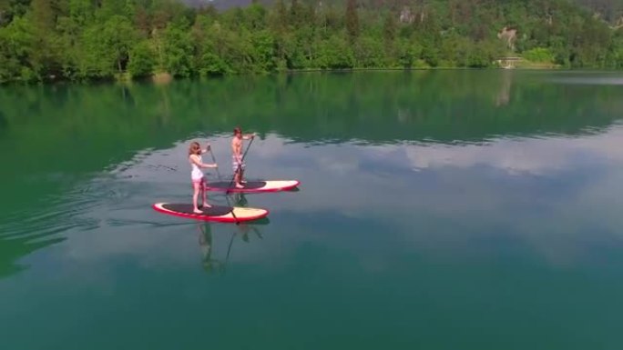 空中: 年轻夫妇在站立桨板上登船
