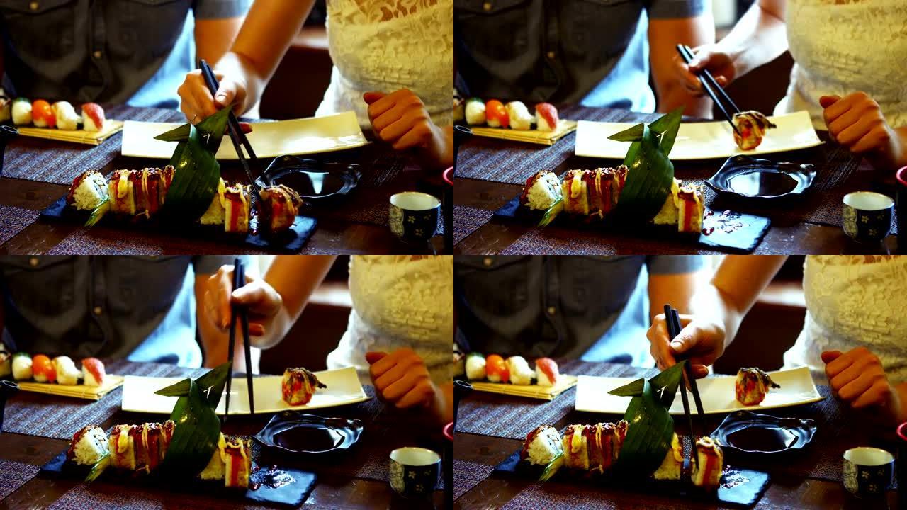 女人在餐厅用筷子在盘子上吃寿司