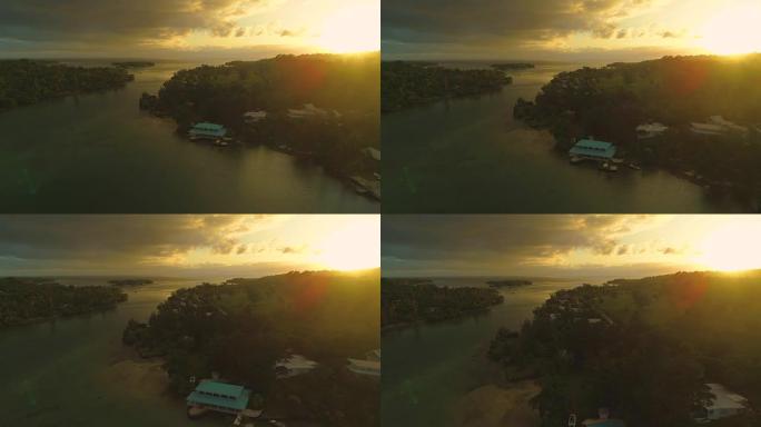 空中: 令人惊叹的夏日日落照亮了瓦努阿图的海滨房屋。