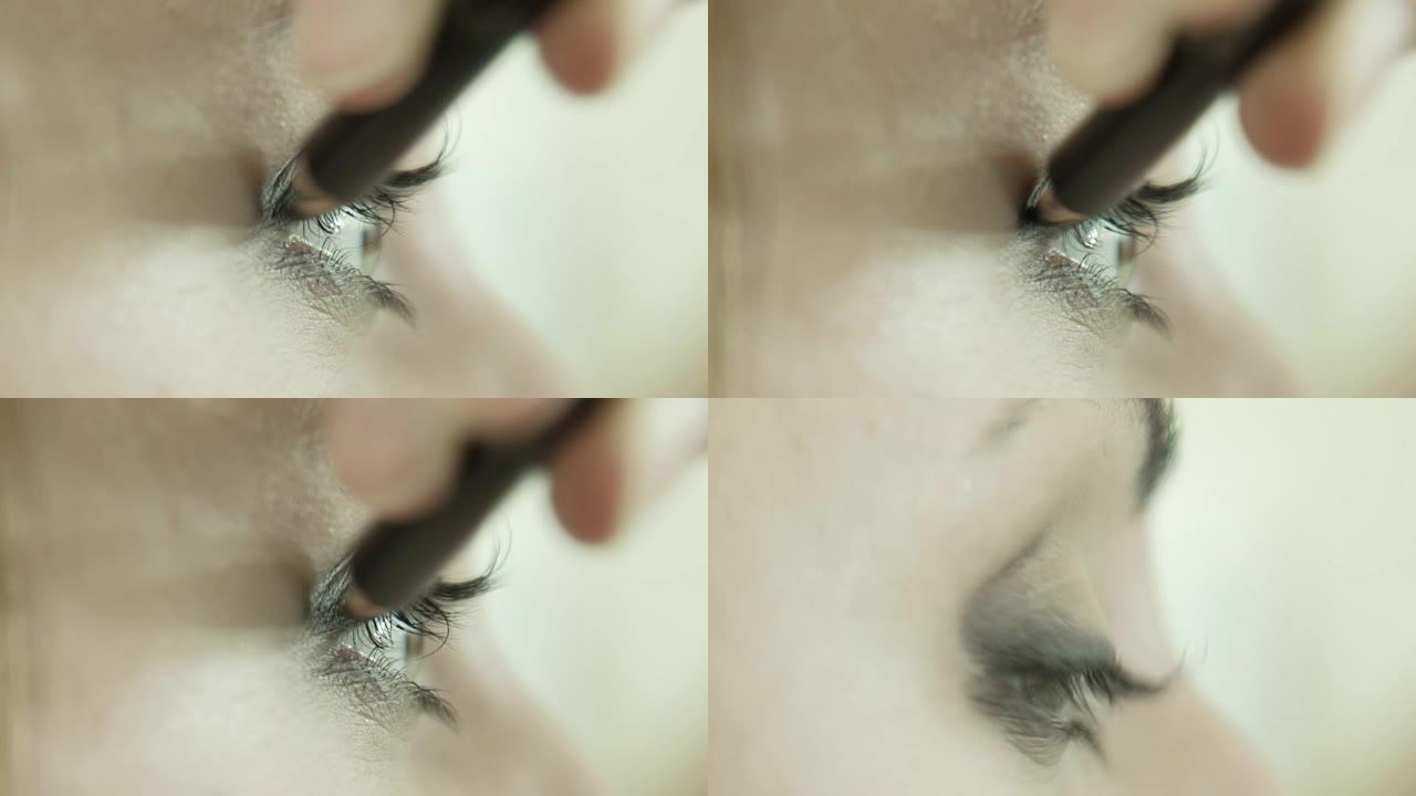 化妆师在眼睑上涂眼线笔。