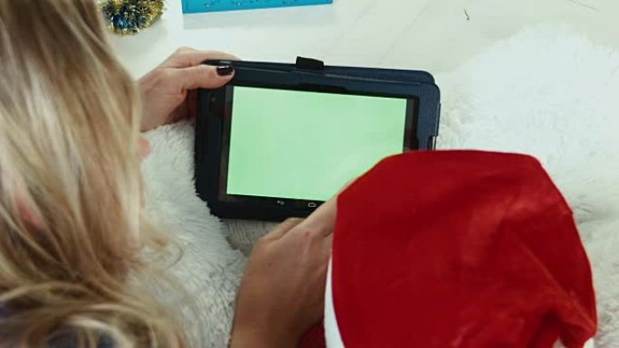 妈妈用带绿屏的触摸板阅读圣诞故事