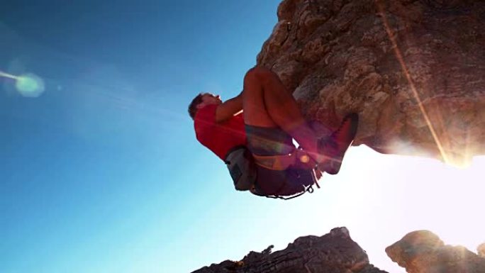 悬挂在岩石上的极端自由攀爬人的低角度