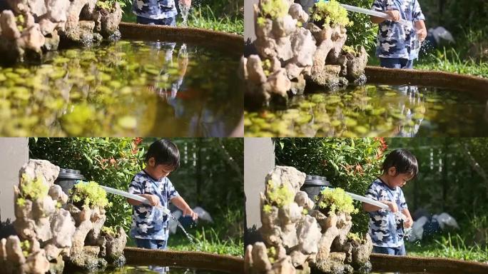 男婴在鱼塘周围玩耍。