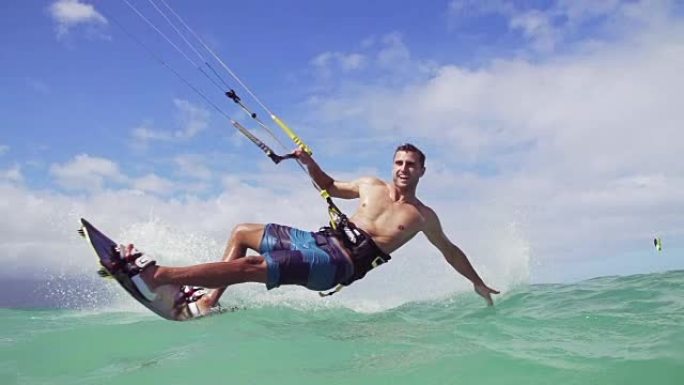 男子风筝在夏日在海洋中冲浪，极限运动