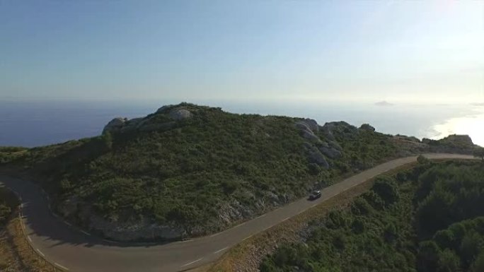 空中: 夏季傍晚沿着山口路行驶的汽车