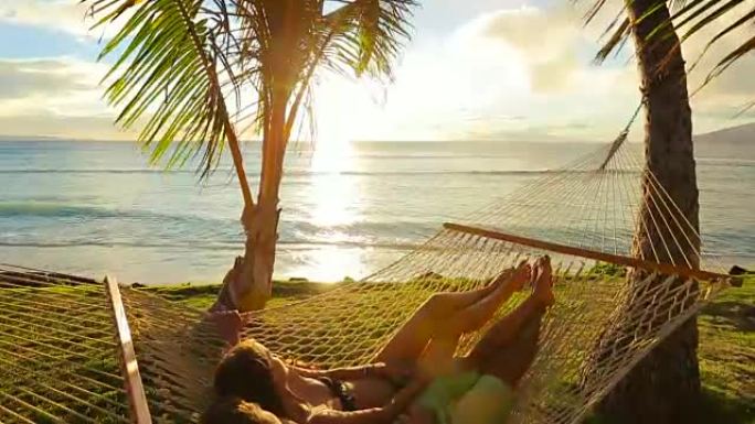 日落时在热带吊床上放松的浪漫情侣