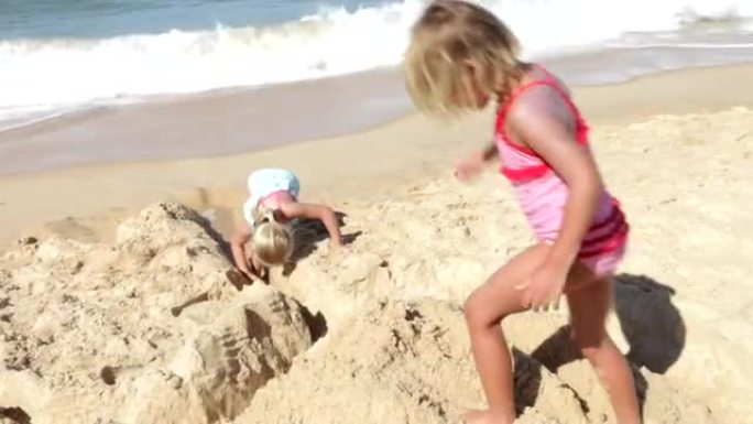 两个年轻女孩一起在海滩上玩耍