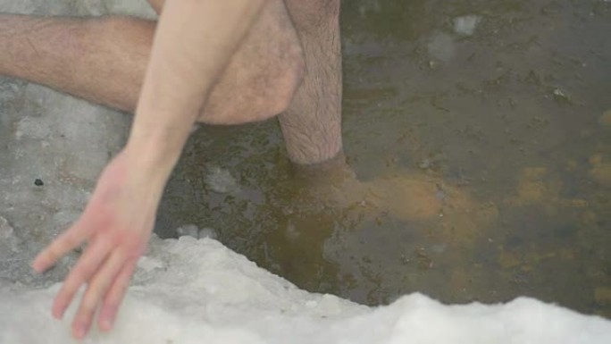 雄性的腿小心翼翼地进入冰洞水。