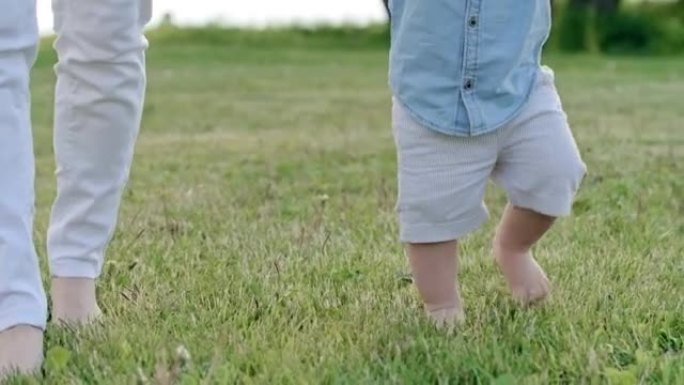 好奇的蹒跚学步的孩子赤脚在草地上行走