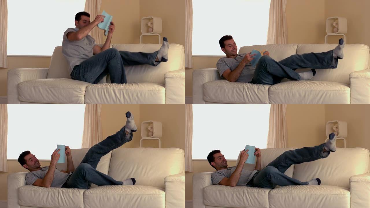 迷人的男人带着书跳上沙发