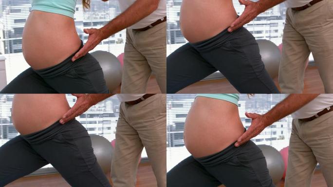 孕妇与私人教练一起做瑜伽