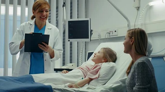康复中的小女孩躺在医院的床上，友好的医生拿着剪贴板问哪里疼，母亲坐在床边。现代儿科/儿童病房里可爱的