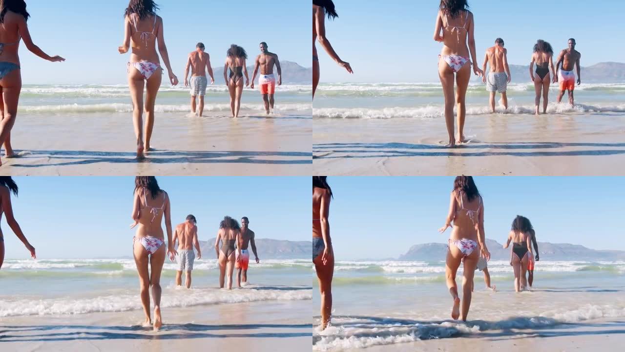一群朋友在海滩度假时沿着海岸线散步