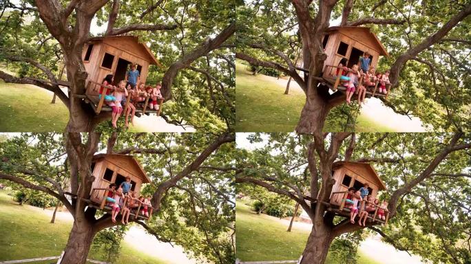孩子们坐在绿叶树上的树屋边缘