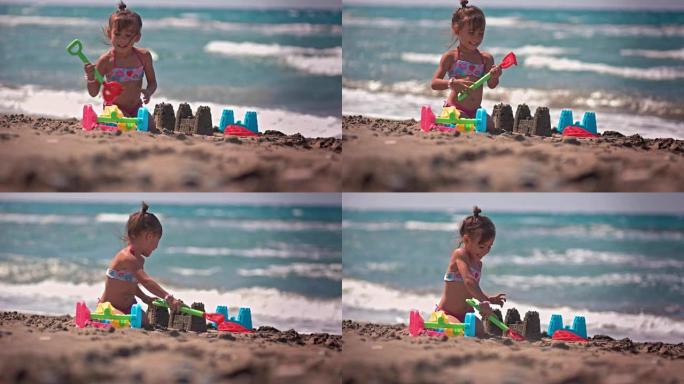 快乐的中国女孩在沙滩上玩耍，建造沙堡