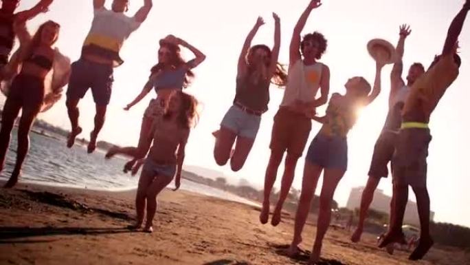 暑假期间，年轻的多民族朋友在海滩上跳跃