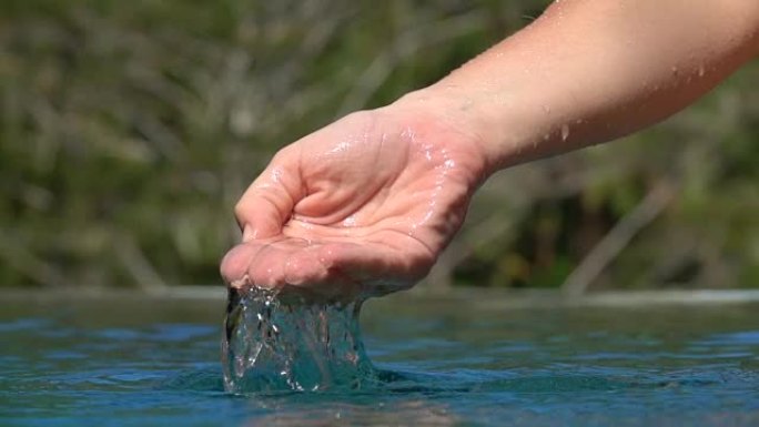 慢动作: 女性手舀水，水滴落在游泳池表面