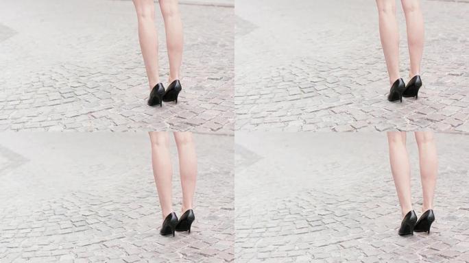 穿着高跟鞋在城市里散步的年轻女子。腿部特写