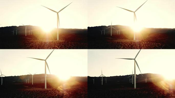 风车在日落时在沙漠中旋转，镜头耀斑创造清洁能源