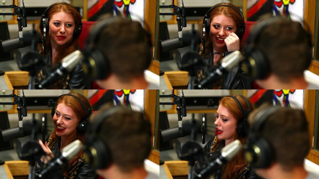 漂亮的学生在演播室采访某人的广播