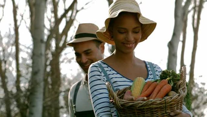 幸福的年轻夫妇带着一盒蔬菜