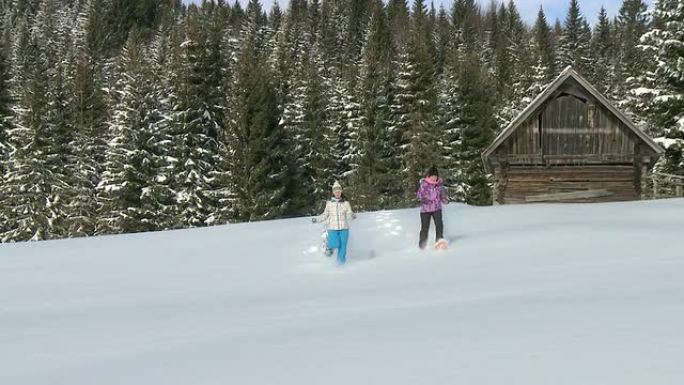 高清：年轻女孩在雪地上穿雪鞋。