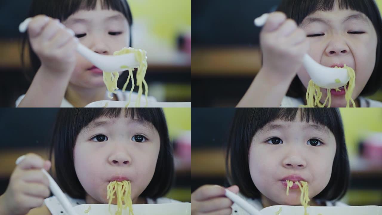 吃面条的亚洲小女孩。