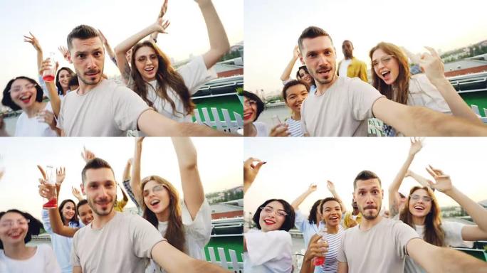 大胡子的家伙受欢迎的博客作者在现代露天聚会上录制互联网vlog视频的观点镜头，朋友跳舞和大笑。